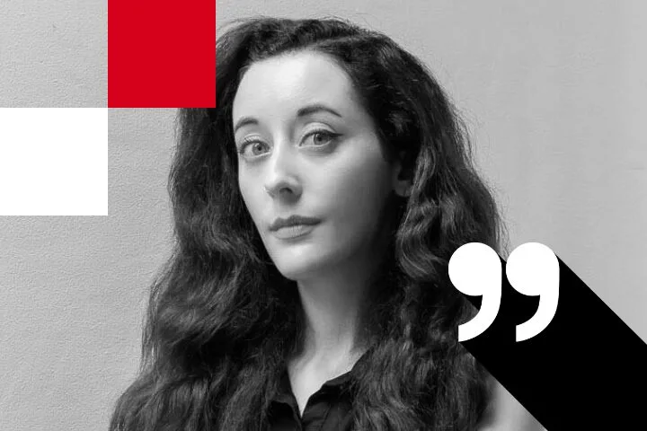 A person with long, wavy hair wearing a dark top is looking at the camera. The image is in black and white with red and white squares and a quotation mark graphic overlay.